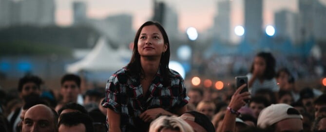 a woman standing on her shoulders in front of a crowd of people