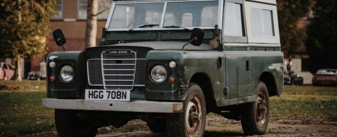 a green and white vehicle parked on dirt