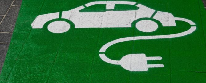 a green and white painted sign on a sidewalk