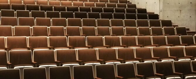 a rows of brown chairs in a auditorium
