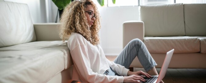 a woman sitting on the floor with a laptop
