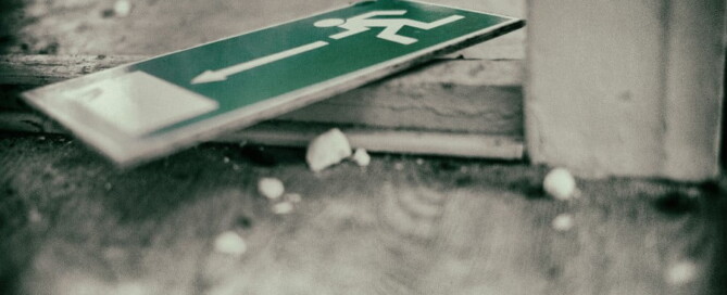 a green sign on a wooden surface