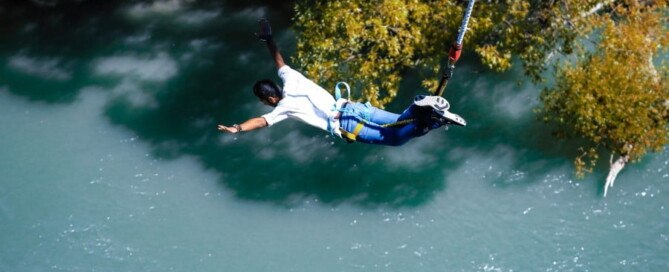 a person bungee jumping over water
