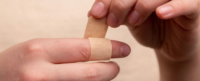a person putting a band aid on a finger