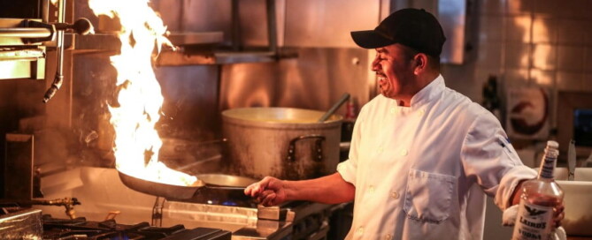 a man in a kitchen with a fire