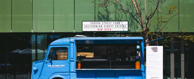 a blue food truck parked in front of a building