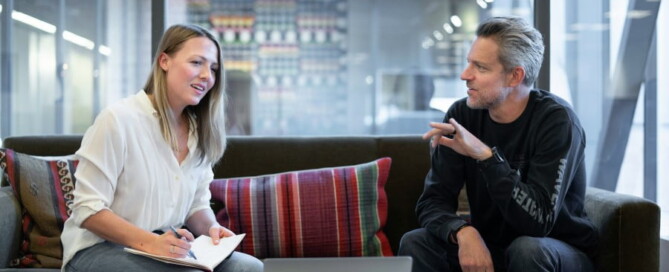 a man and woman sitting on a couch talking