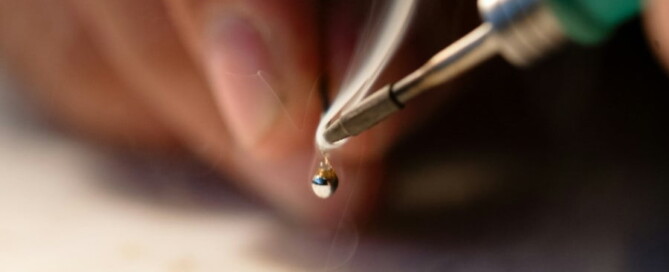 a hand holding a soldering iron
